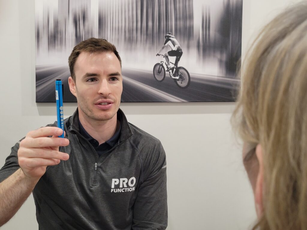 Dr. Joseph Greenwood conducting and eye exam for concussions